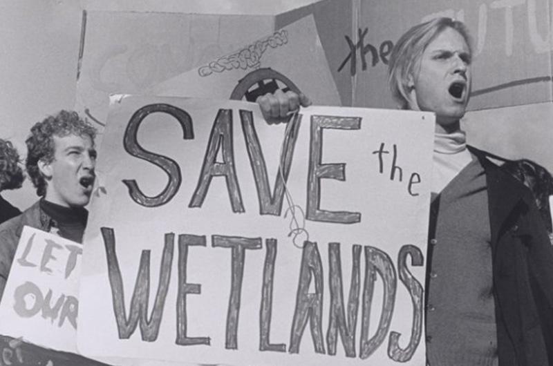 Students holding posterboards reading "Save the Wetlands"