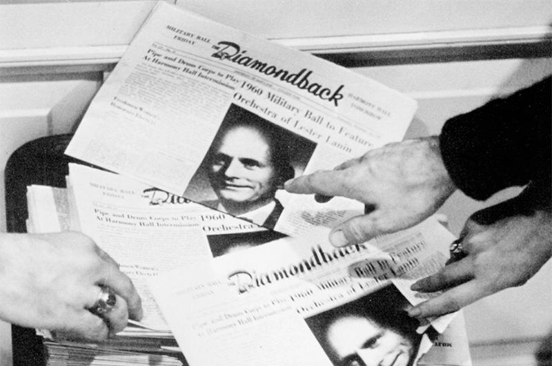 multiple hands point to a cover of The Diamondback
